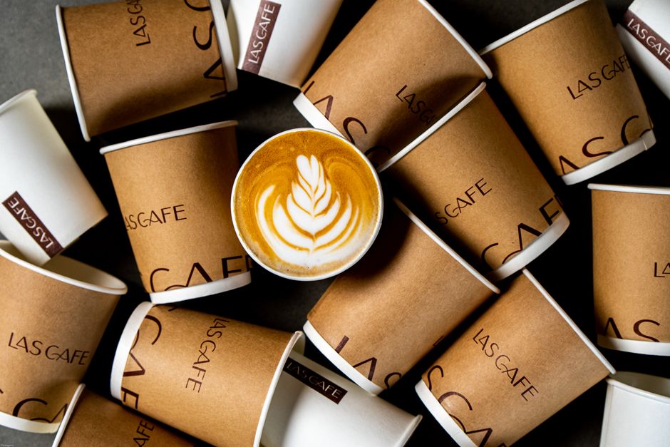 Barista pripravuje cappuccino v papierovom pohári